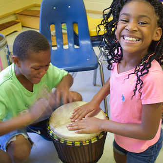 Girl and boy drumming.