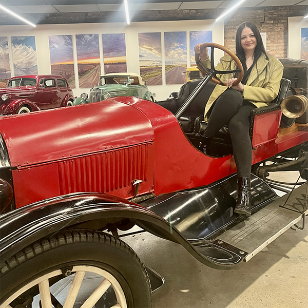 Meghan in a classic old car.